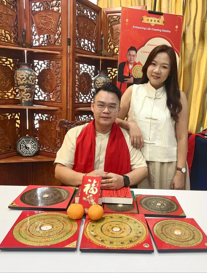 Master Jeremy Khai with his wife at the 青靈堪輿 consultancy, with Luo Pan compasses on the table